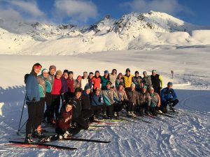 group of young skiers posing in a snowcovered valley with blue sky
